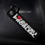 Keychain with 'I love being a problem' text on a black textured surface