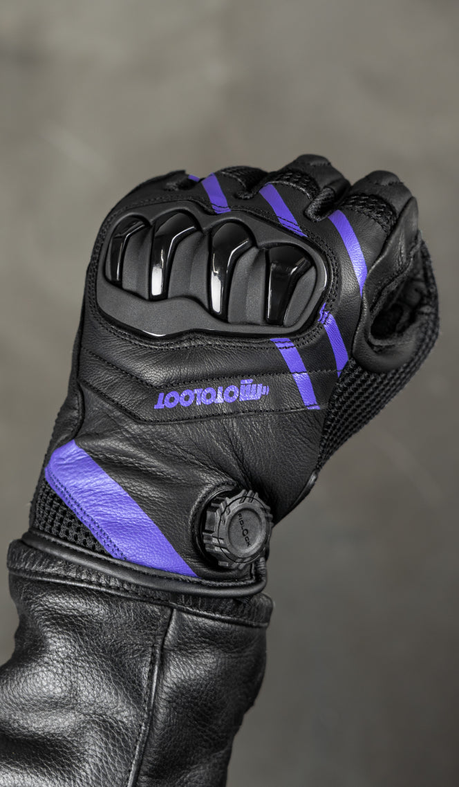 Black leather glove with purple accents on a gray background
