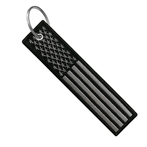 Grey-black keychain with matt patinated surface, metal arrow